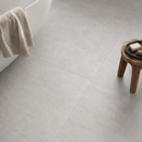 Vloertegel betonlook Concrete Grey 100 x 100 cm - detailopname betonlook vloer bij bad in grijs