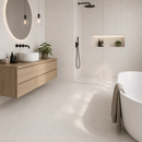 Vloertegel steenlook Vida Blanco 100 x 100 cm in badkamer met inloopdouche en houten meubel – sfeerfoto